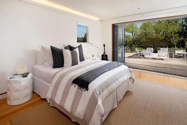 a bedroom with bed and a large window