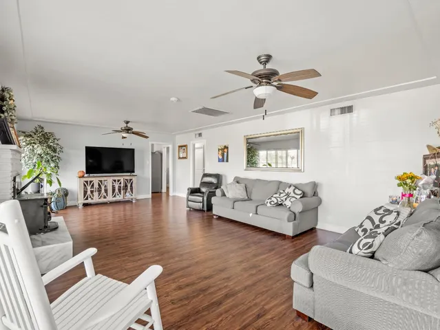 a view of a livingroom with furniture a fireplace window and wooden floor