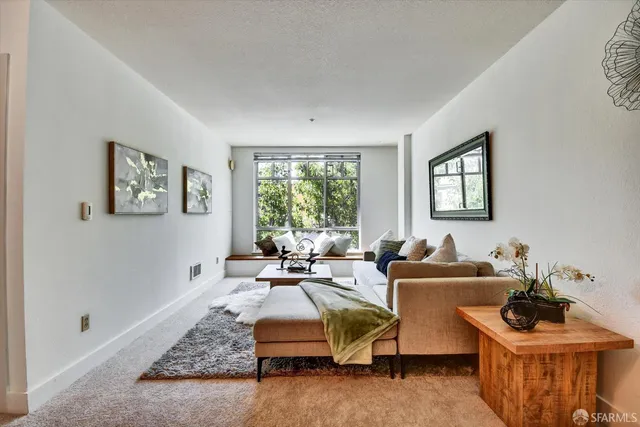 a view of a hallway with wooden floor and a refrigerator