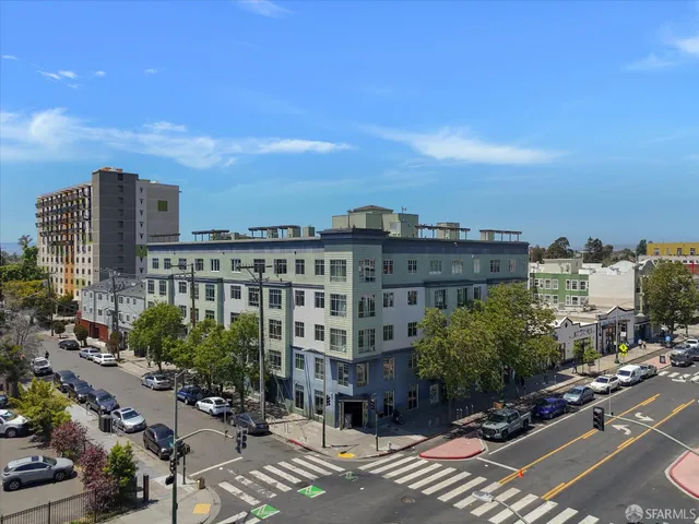a view of a city that has tall buildings and cars parked in front of it