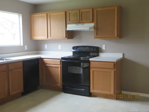 a kitchen with sink a microwave and cabinets