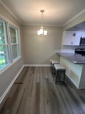 a view of a room with wooden floor a sink and windows