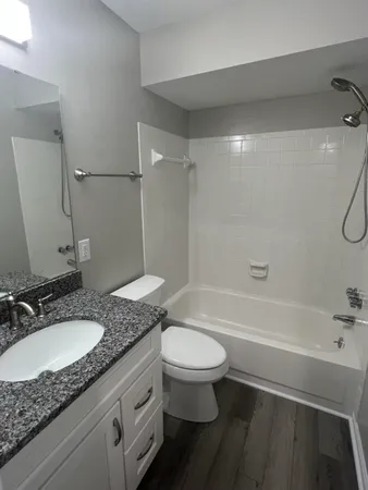 a bathroom with a granite countertop sink toilet and shower