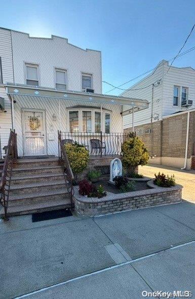 66-18 75th Street Queens, NY 11379 - Photo 1 of 1 a front view of a house with a garden