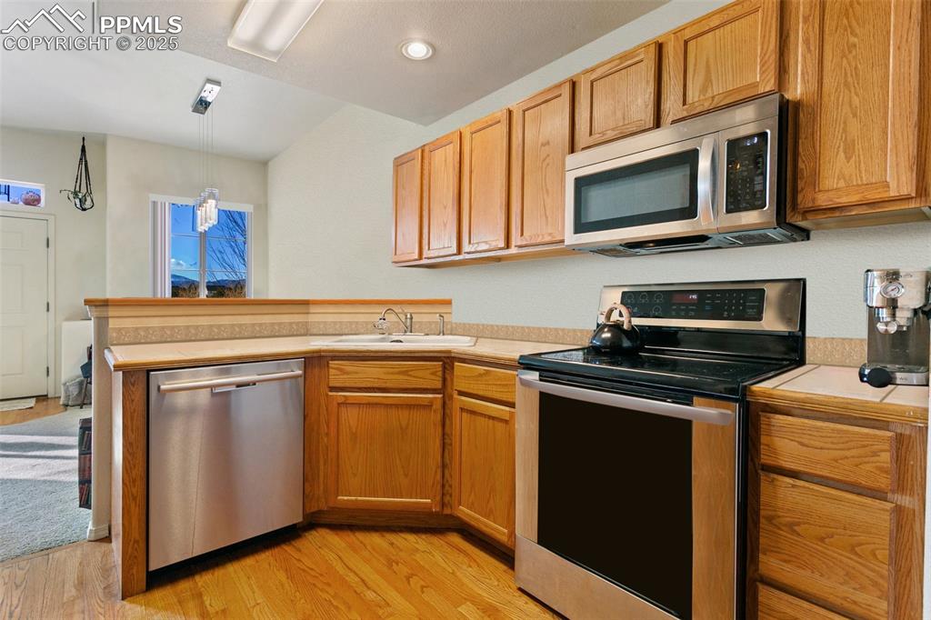 7022 Sand Crest View Colorado Springs, CO 80923 - Photo 5 of 13 a kitchen with stainless steel appliances granite countertop a stove microwave and sink