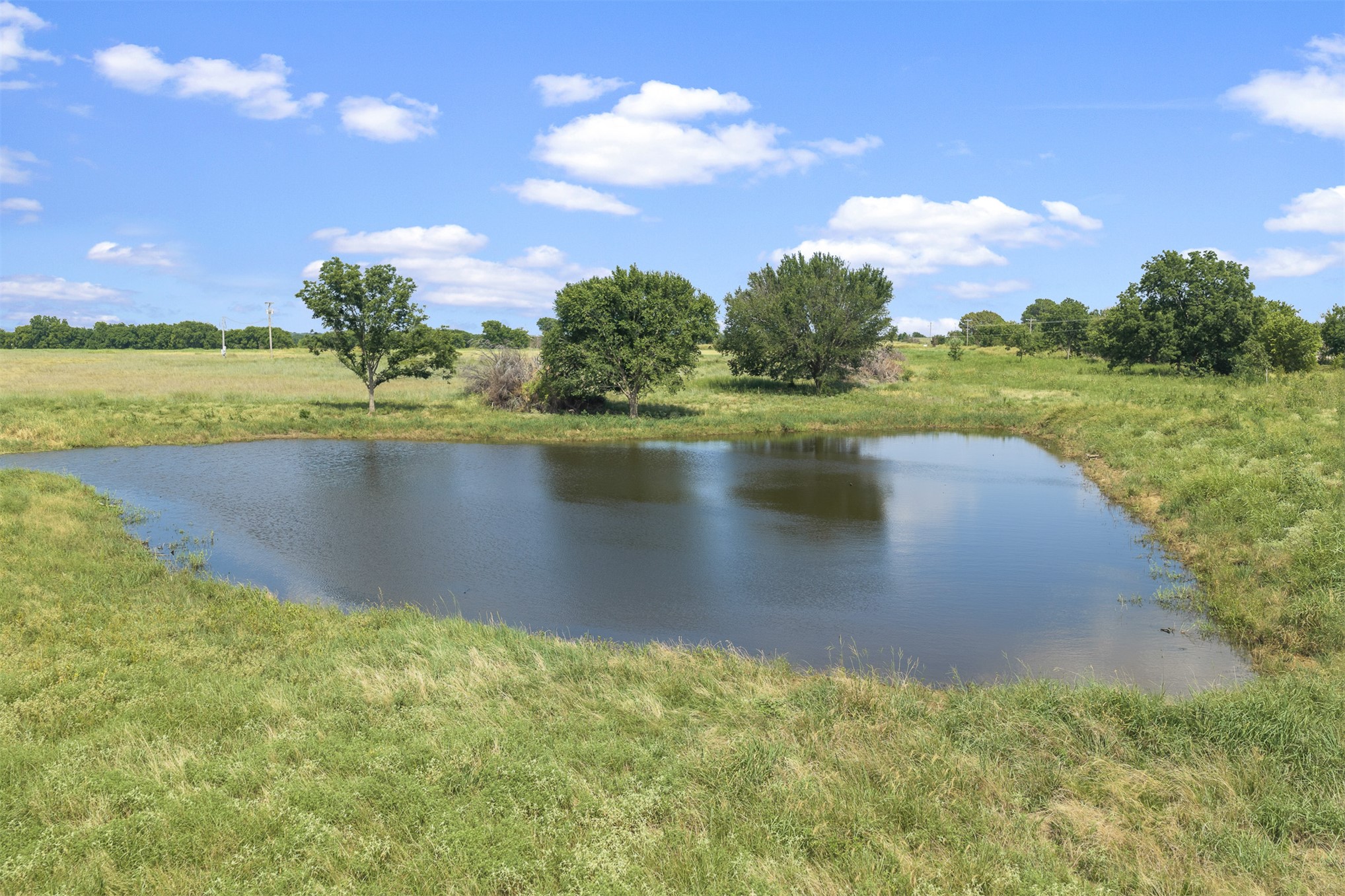 4 Keller Road Wilson, OK 73463 - Photo 10 of 32 Natural pond feature surrounded by green grass and mature trees