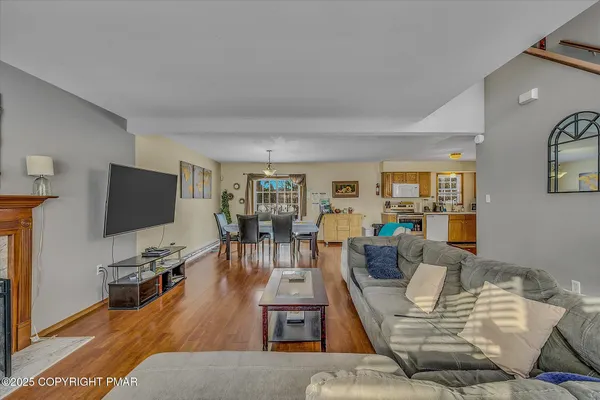 a kitchen with stainless steel appliances granite countertop a refrigerator a stove top oven a sink dishwasher and white cabinets with wooden floor