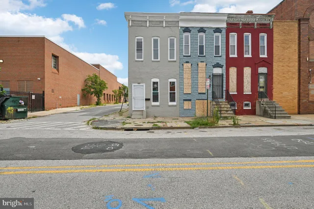 a front view of a building with garage and plants