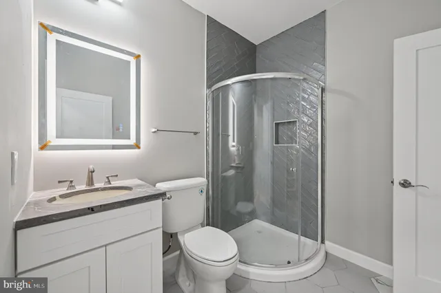 a bathroom with a granite countertop toilet sink and shower
