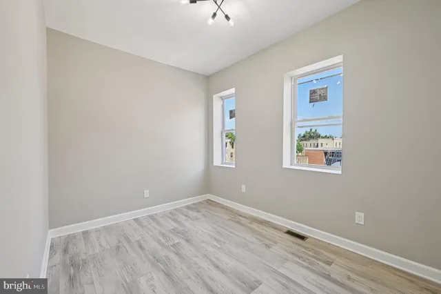 an empty room with a window and a ceiling fan