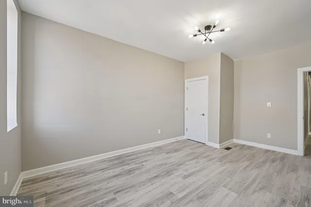 a view of an empty room with a chandelier fan