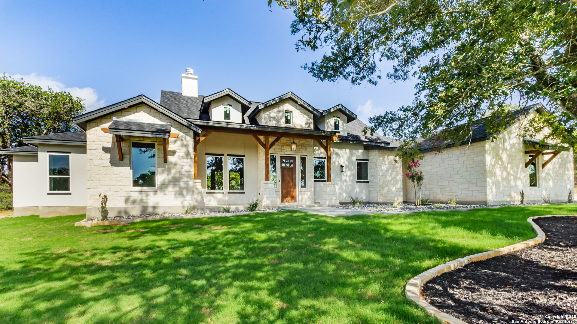 246 Timber Place La Vernia, TX 78121 - Photo 3 of 33 a front view of a house with a garden and trees