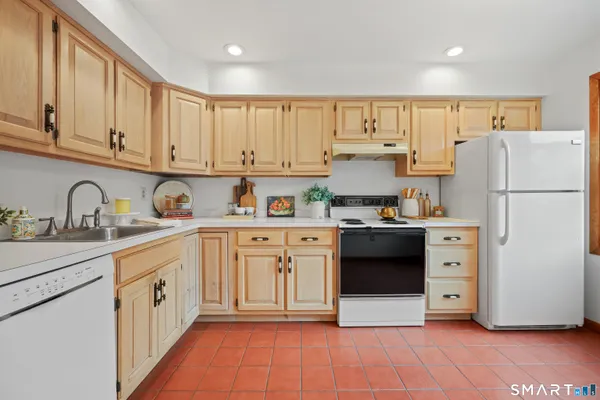a kitchen with white cabinets and white appliances
