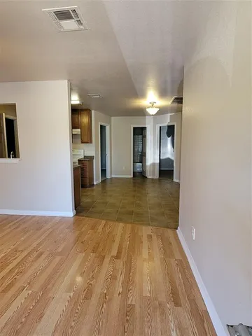 a view of a hallway with wooden floor