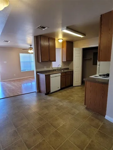 a large kitchen with granite countertop a large stove top oven and cabinets