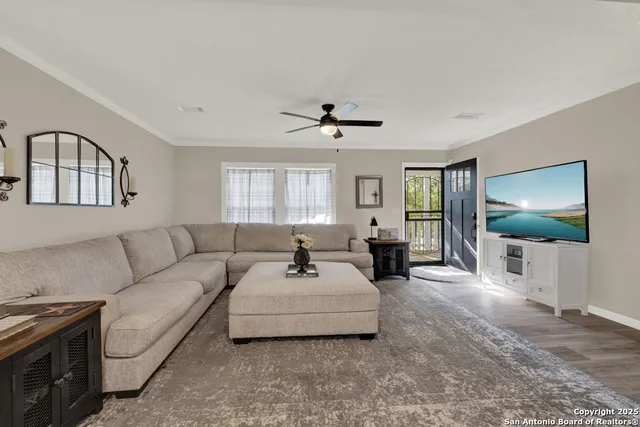 a living room with furniture a flat screen tv and a large window