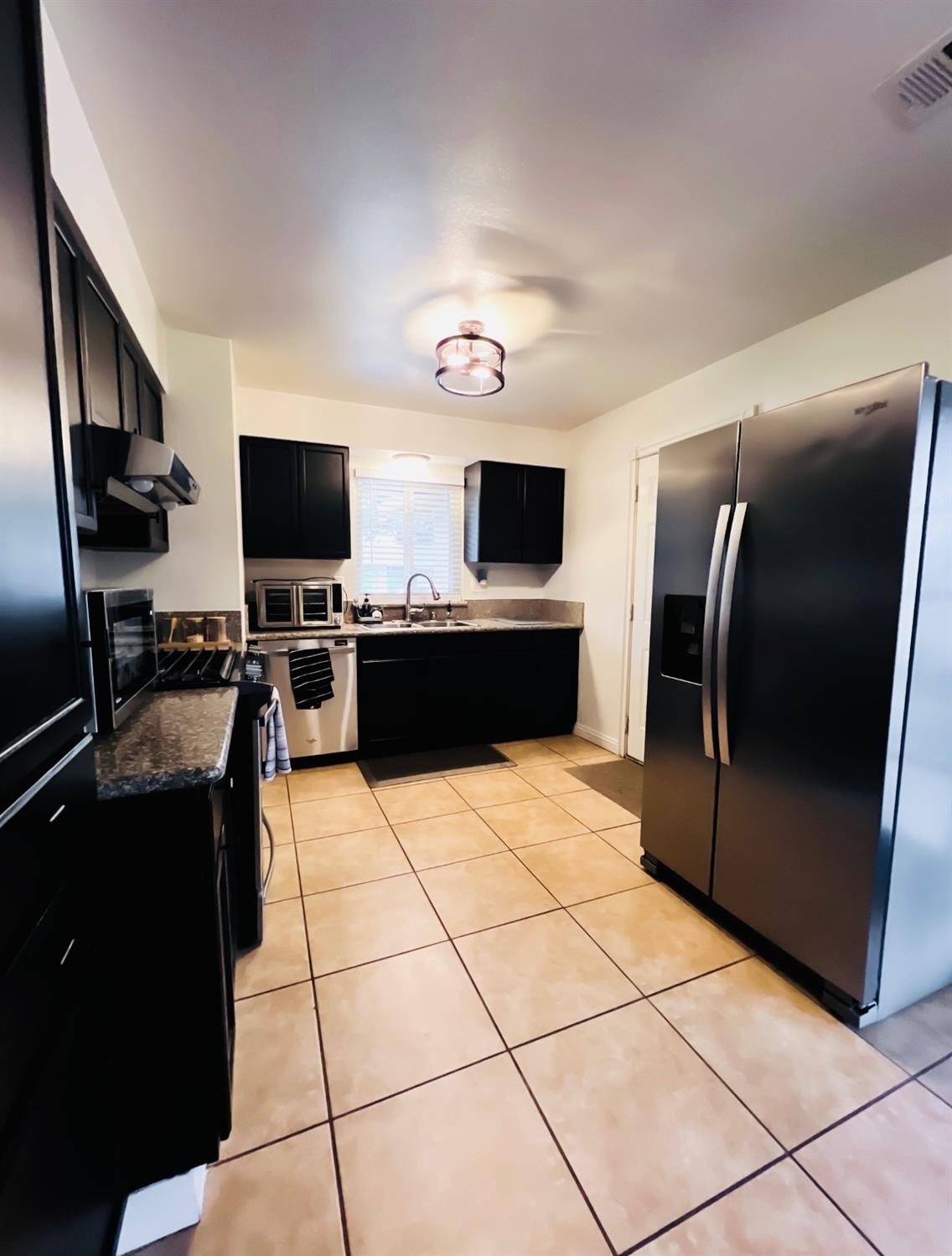 2101 Milford Lane Modesto, CA 95355 - Photo 5 of 18 a kitchen with stainless steel appliances granite countertop a refrigerator and a stove top oven
