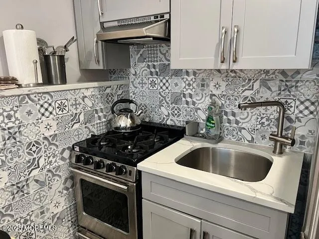 a close view of a sink and a stove in a bathroom