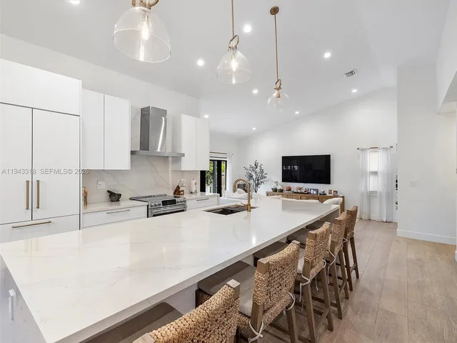 a kitchen with stainless steel appliances a stove top oven a sink a refrigerator a microwave and cabinets