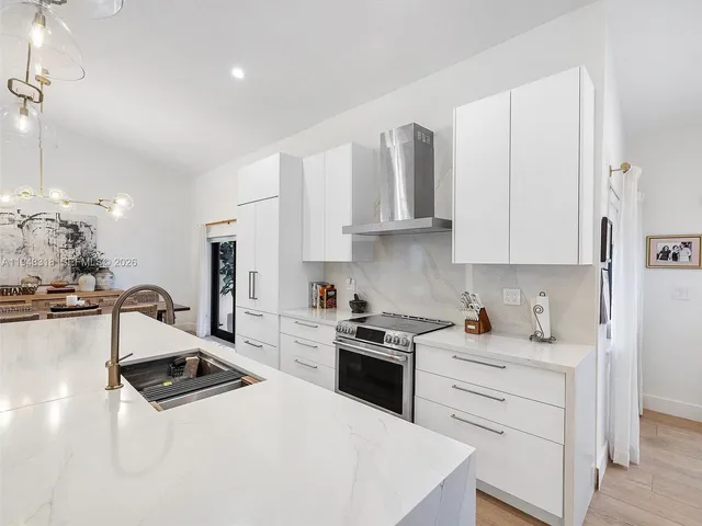 a kitchen with granite countertop a sink stainless steel appliances and cabinets