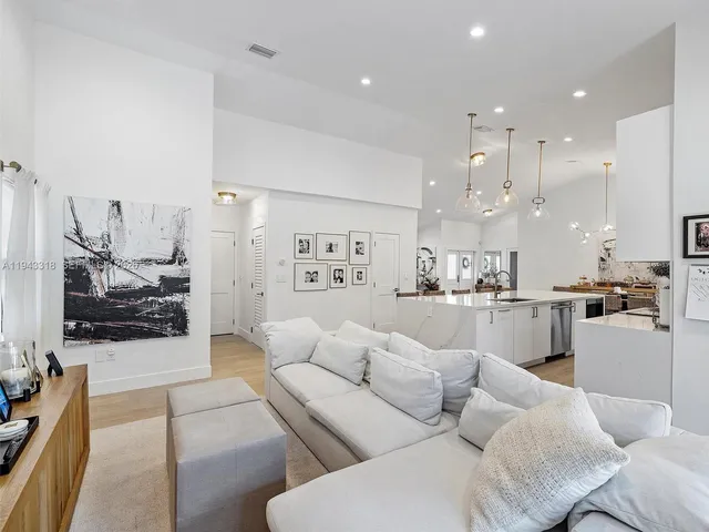 a living room with furniture and a view of kitchen