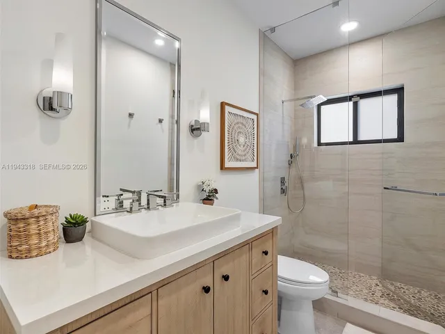 a bathroom with a sink a toilet and shower