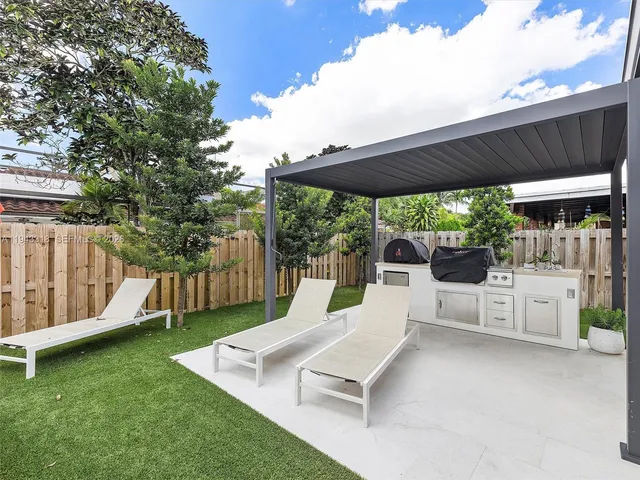 a view of a patio with table and chairs potted plants with wooden fence
