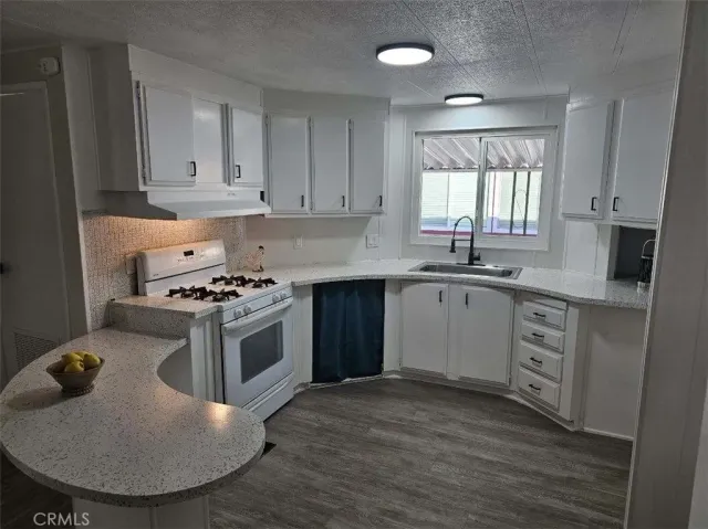 a kitchen with a stove a sink a refrigerator and window