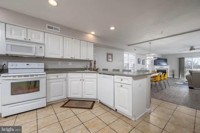 a kitchen with granite countertop cabinets and white stainless steel appliances