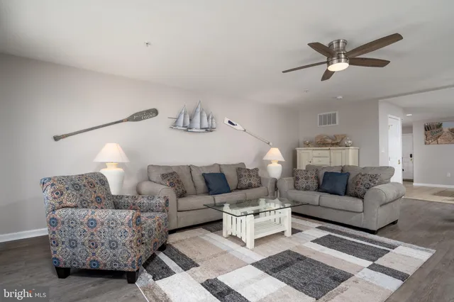 a living room with furniture and a ceiling fan
