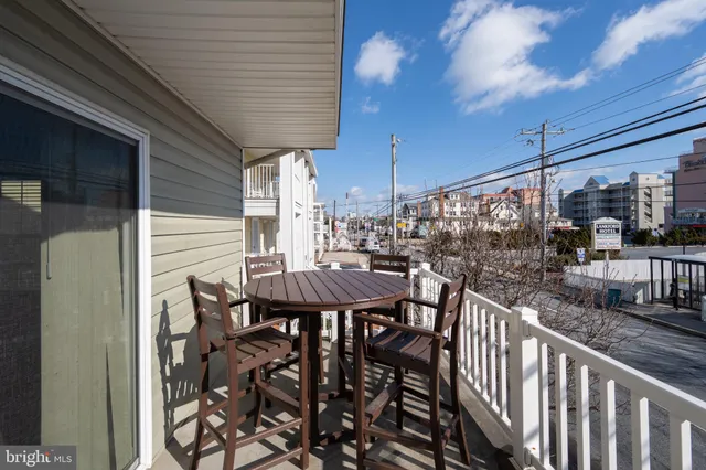 a view of a patio with table and chairs with wooden floor and fence