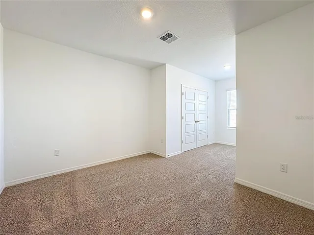 an empty room with white wall and closet