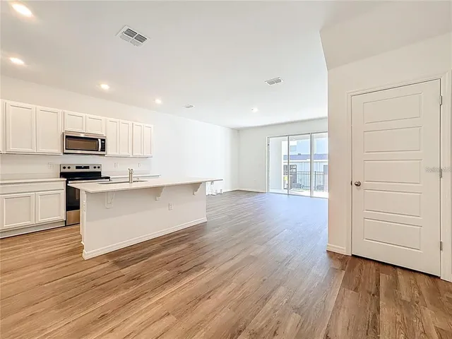a kitchen with wooden floors and white appliances