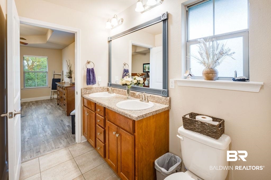 22281 Respite Lane Foley, AL 36535 - Photo 16 of 31 Primary Bathroom featuring hardwood / wood-style floors, vanity, toilet, and ceiling fan