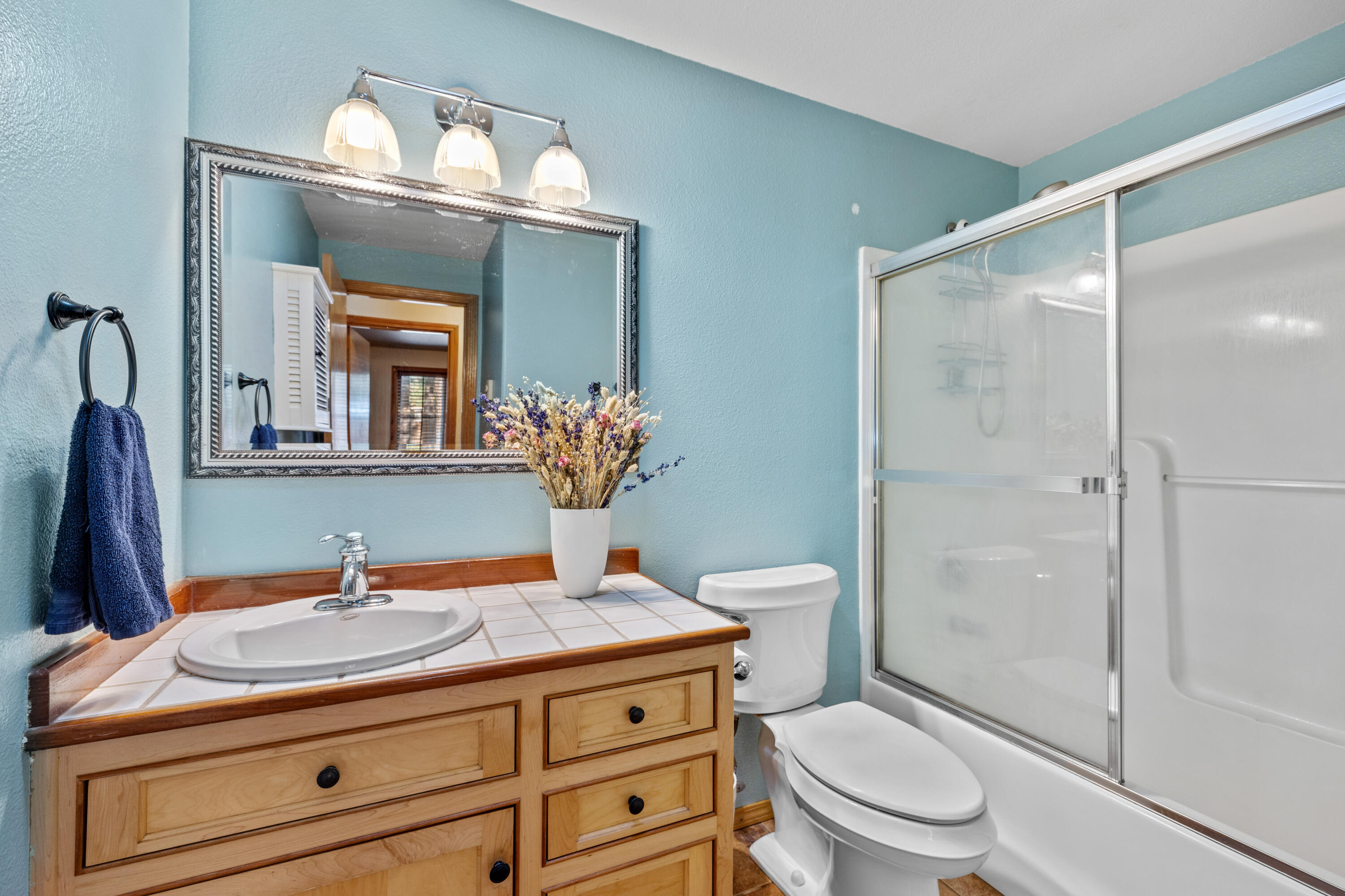 19102 Choctaw Road Bend, OR 97702 - Photo 10 of 14 a bathroom with a granite countertop sink a toilet a mirror and shower