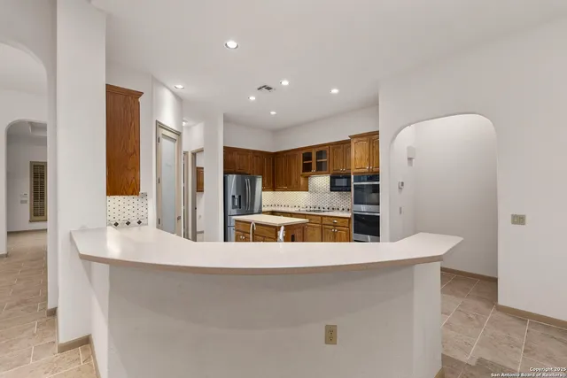 a large kitchen with stainless steel appliances a large counter top
