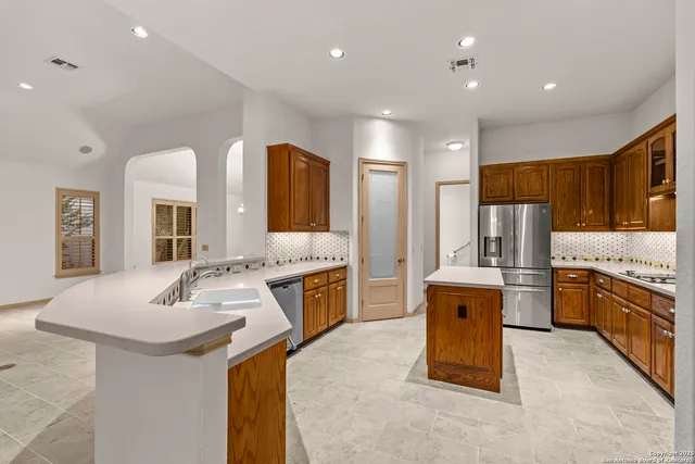 a kitchen with stainless steel appliances granite countertop a sink stove and refrigerator