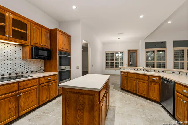 a kitchen with stainless steel appliances granite countertop a sink and dishwasher a stove top oven with wooden floor