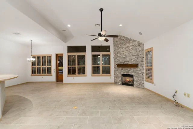 a view of an empty room with a fireplace and a window