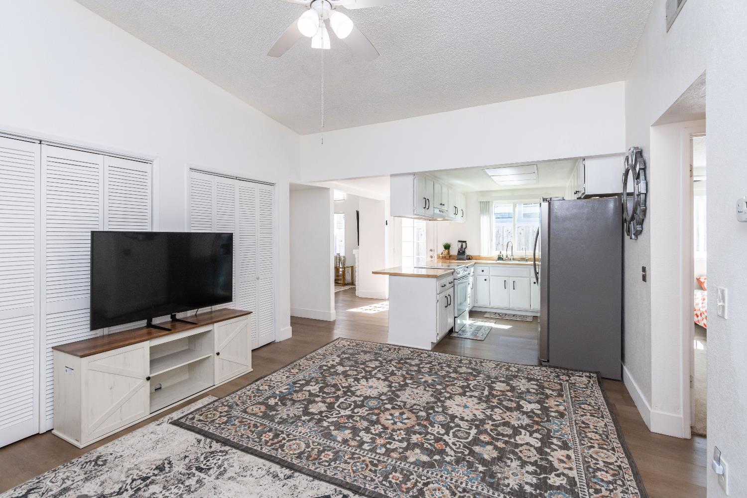 2000 Inglis Way, Unit A Roseville, CA 95678 - Photo 19 of 45 a living room with a flat screen tv and a dining table with wooden floor