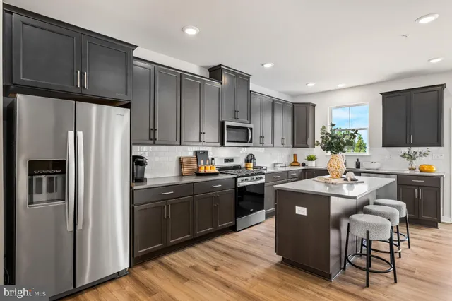 a kitchen with granite countertop a refrigerator stove top oven and sink