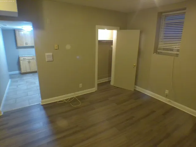 a view of a room with wooden floor and a bathroom