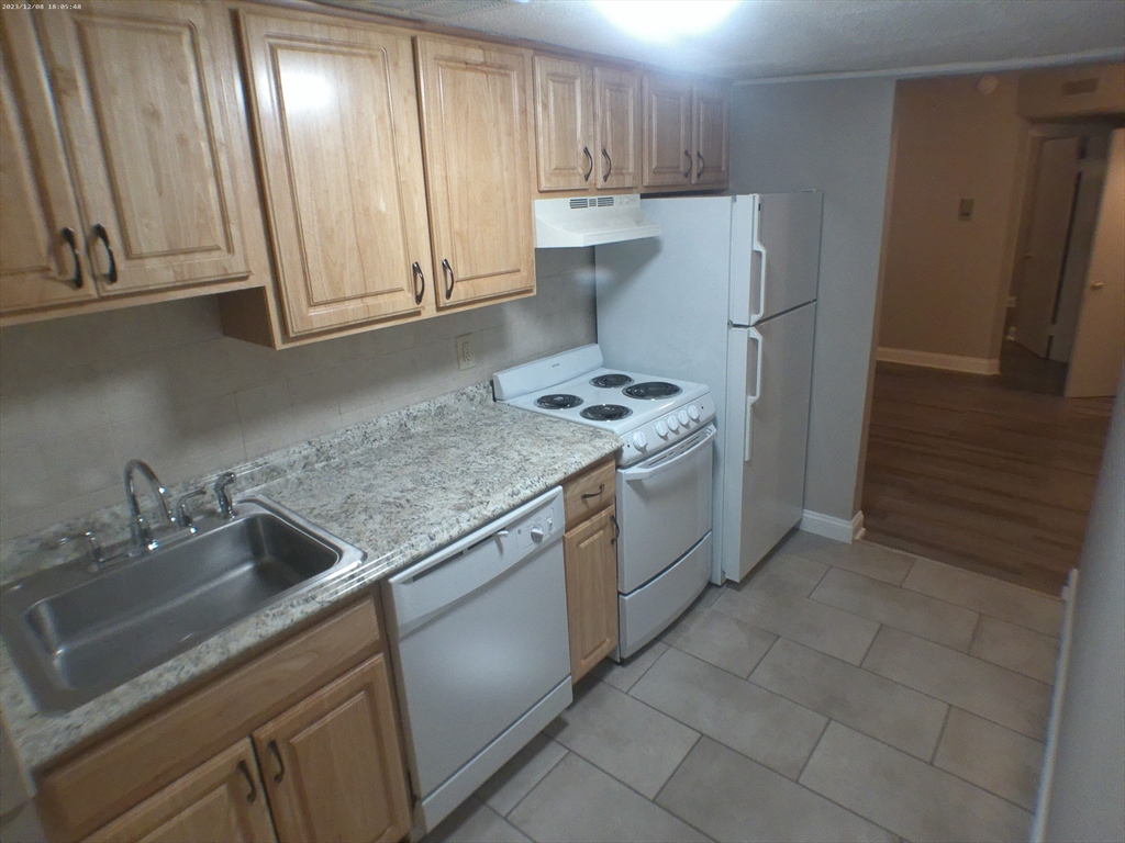 1862 Beacon Street, Unit 1B3 Brookline, MA 02445 - Photo 14 of 23 a kitchen with stainless steel appliances granite countertop a sink stove and refrigerator