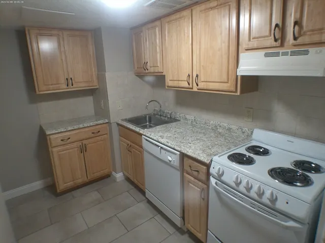 a kitchen with a sink stove and cabinets