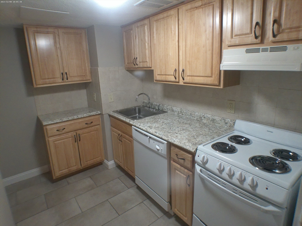 1862 Beacon Street, Unit 1B3 Brookline, MA 02445 - Photo 15 of 23 a kitchen with a sink stove and cabinets