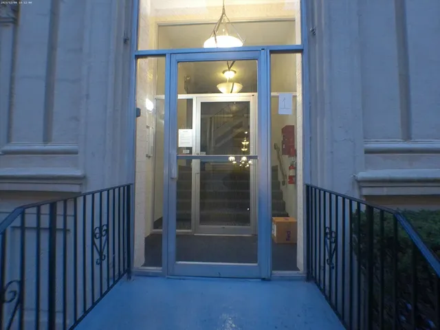 a view of a hallway with wooden floor and entryway