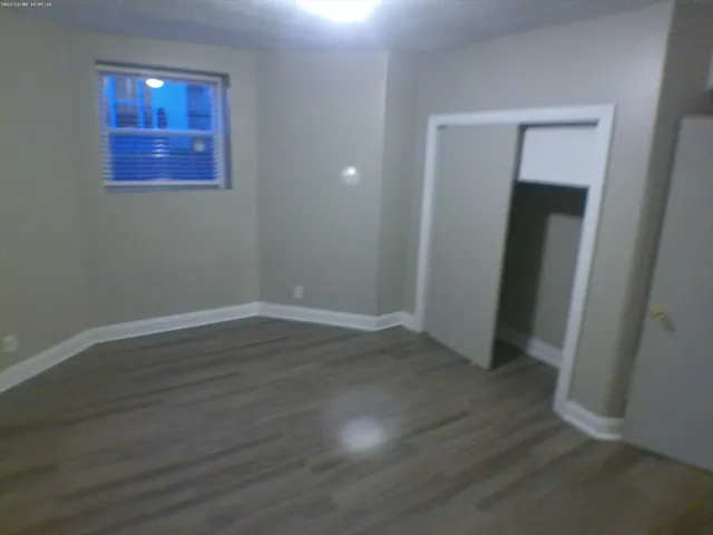 an empty room with wooden floor and closet