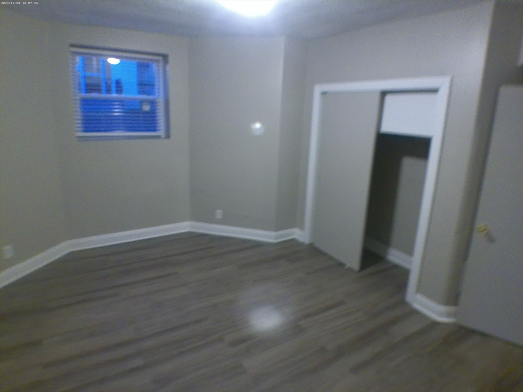1862 Beacon Street, Unit 1B3 Brookline, MA 02445 - Photo 6 of 23 an empty room with wooden floor and closet