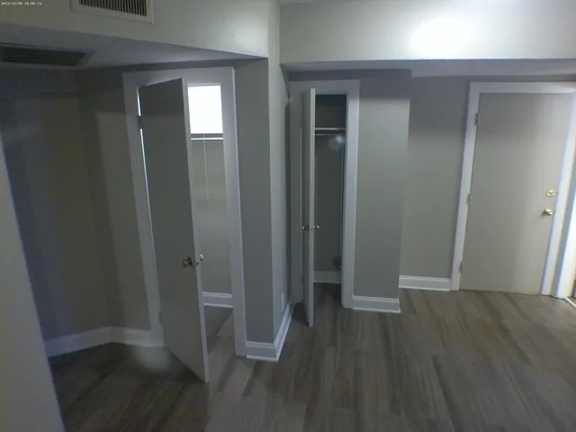 an empty room with wooden floor and closet