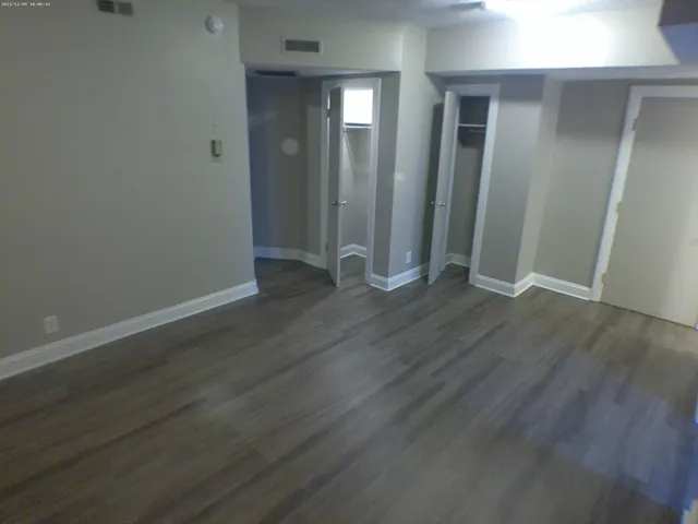 an empty room with wooden floor and closet